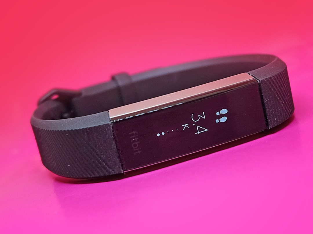 Fitbit Alta HR lay flat and displaying steps distance on screen