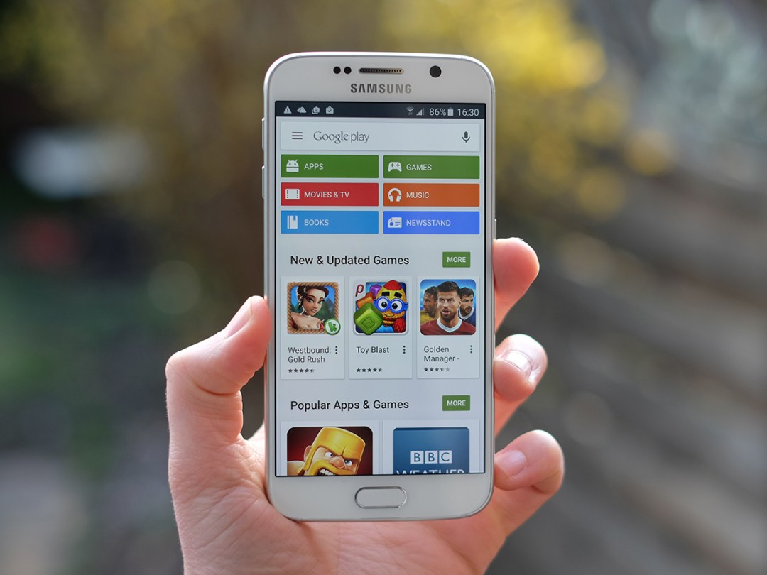 Samsung Galaxy S6 in hand displaying the Google Play apps store