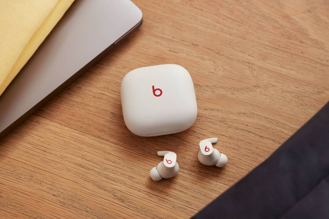 Beats Fit Pro earbuds on desk with charging case