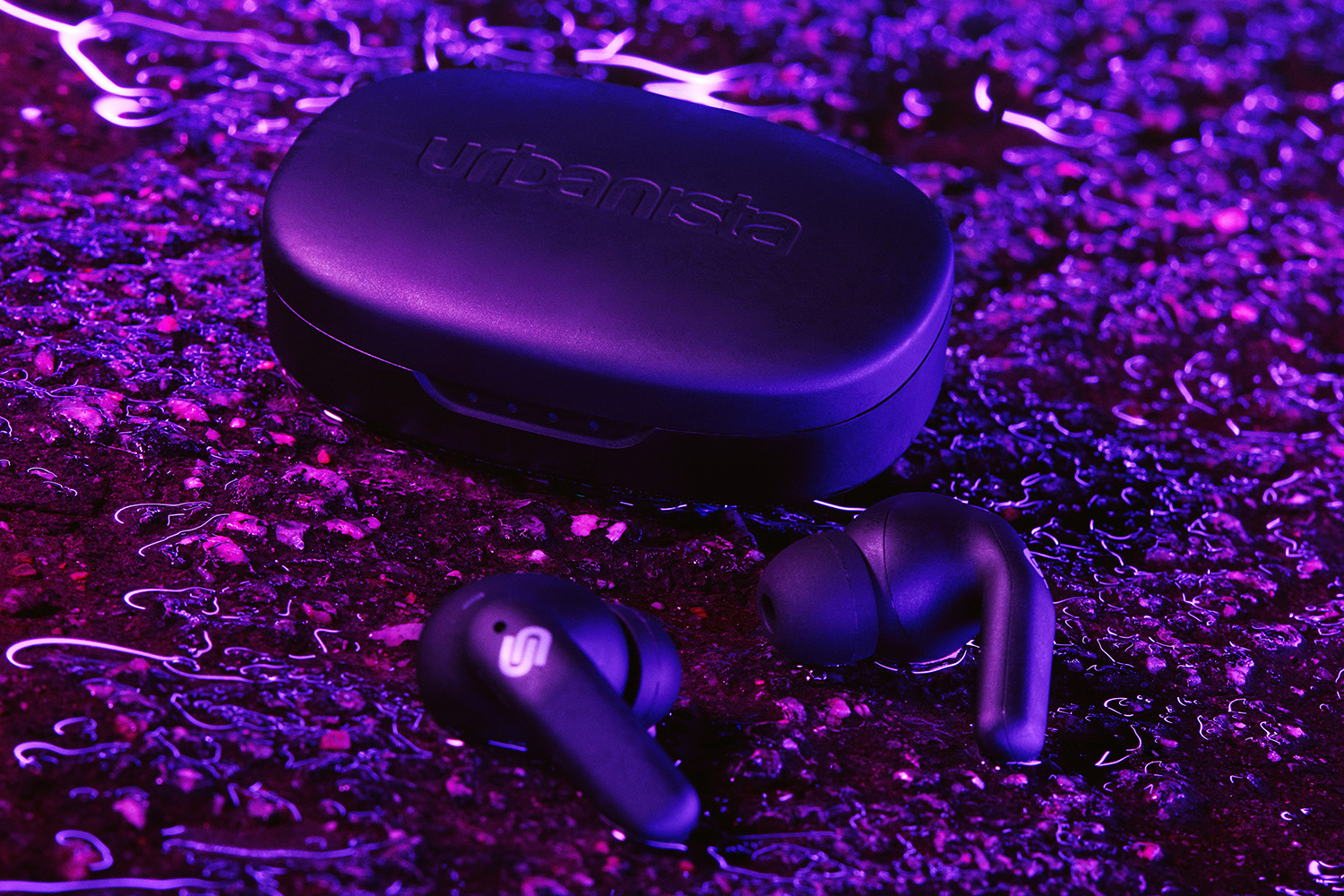 Urbanista Seoul true wireless headphones on wet asphalt