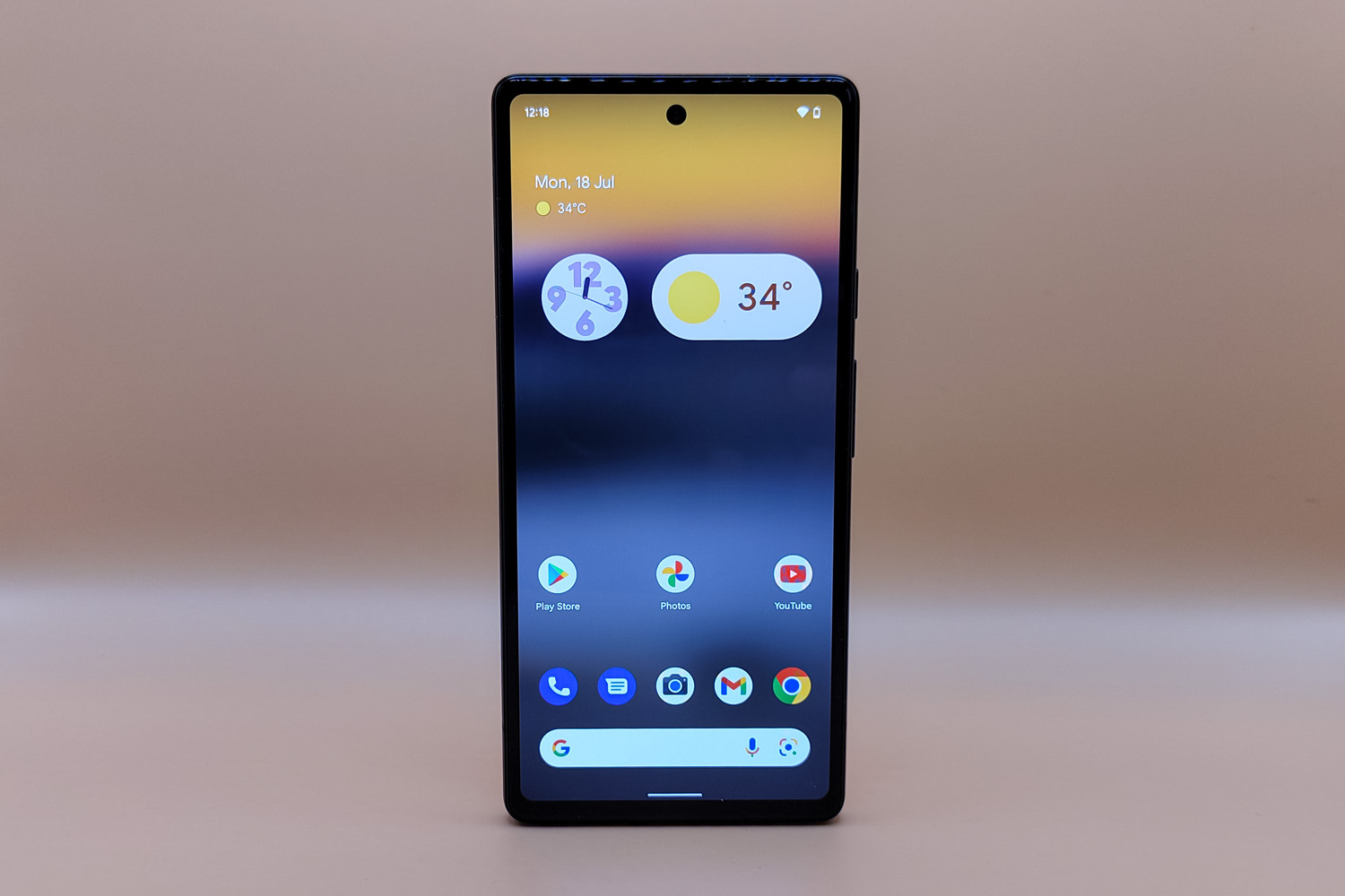 Google Pixel 6a showing the homescreen, on orange background