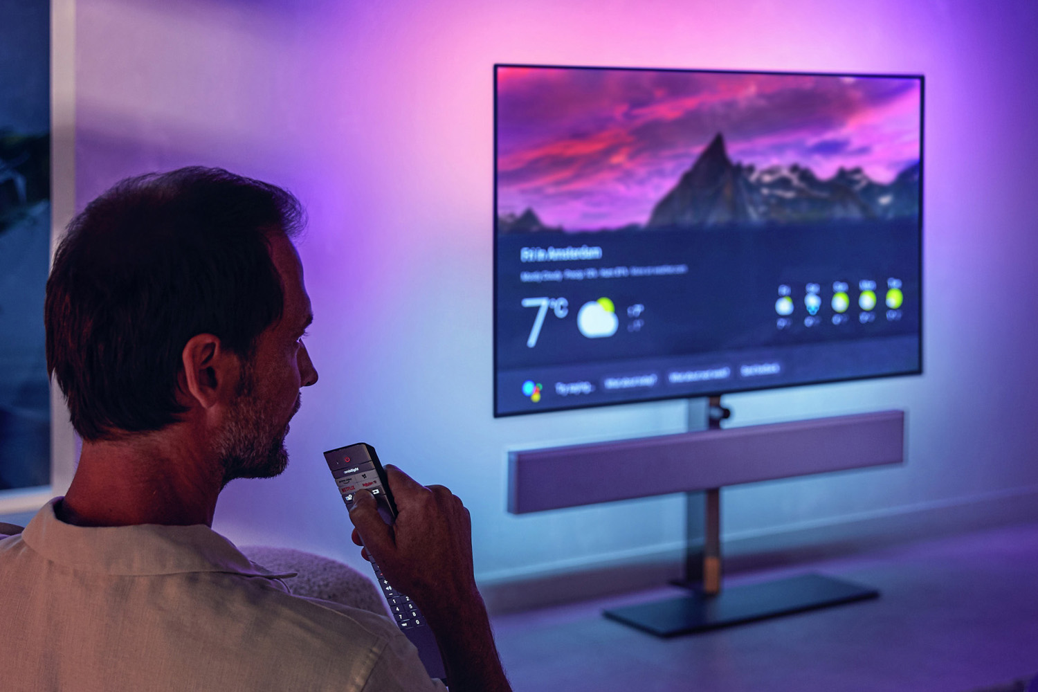 Man using Philips OLED+986 TV remote