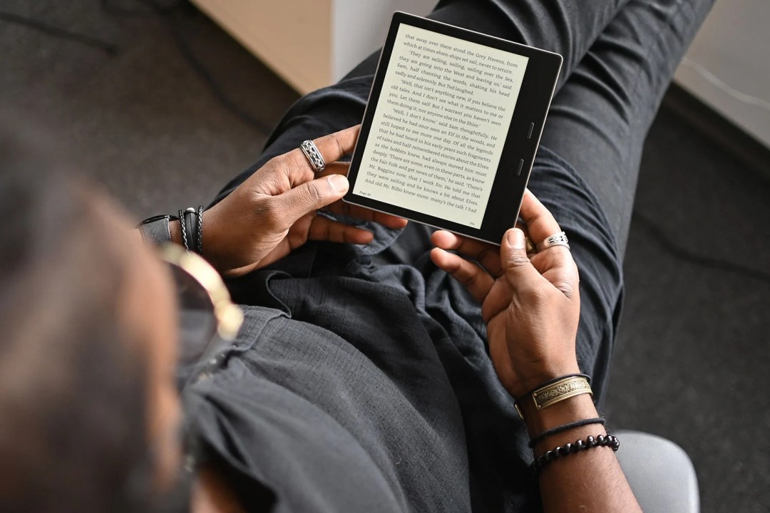 A person reads on a Kindle e-reader