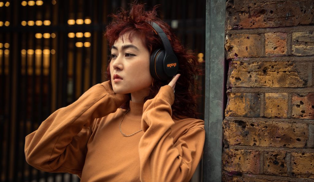Woman wearing Orange's Crest Edition MK2 wireless headphones