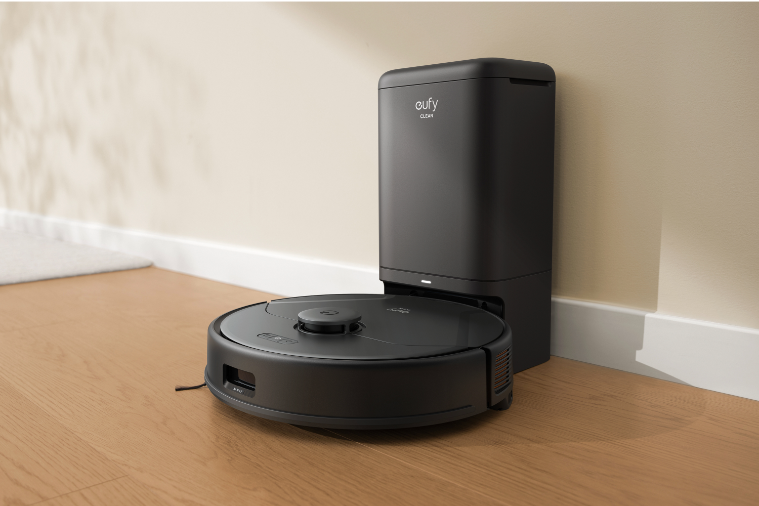 A black Eufy X8 Pro robot vacuum cleaner and base on a wooden floor