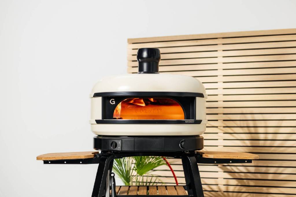 Gozney Dome S1 pizza oven with flames visible inside.