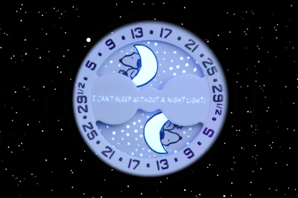 Close up of Snoopy MoonSwatch moonphase complication glowing lume