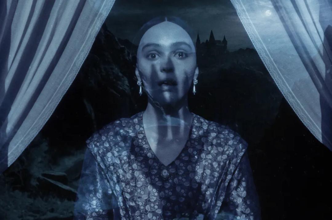 A still from Nosferatu showing the shadow of a long-fingered hand being cast on the face of a woman who looks very scared