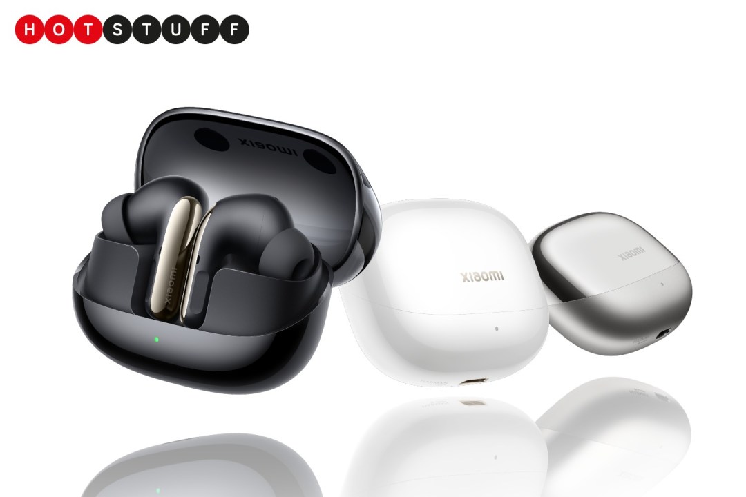 Three cases for wireless ear buds: one black, one white and one grey. The black one is open and a pair of black earbuds are visible inside. The background is white.