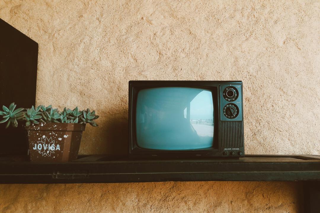 An old-fashioned CRT TV sits on a shelf