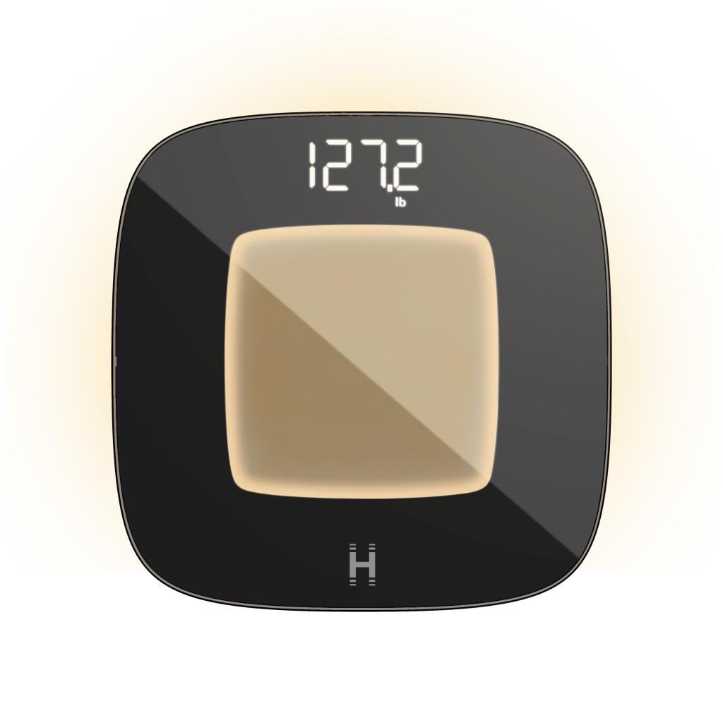 A black and glass smart bathroom scale, glowing yellow