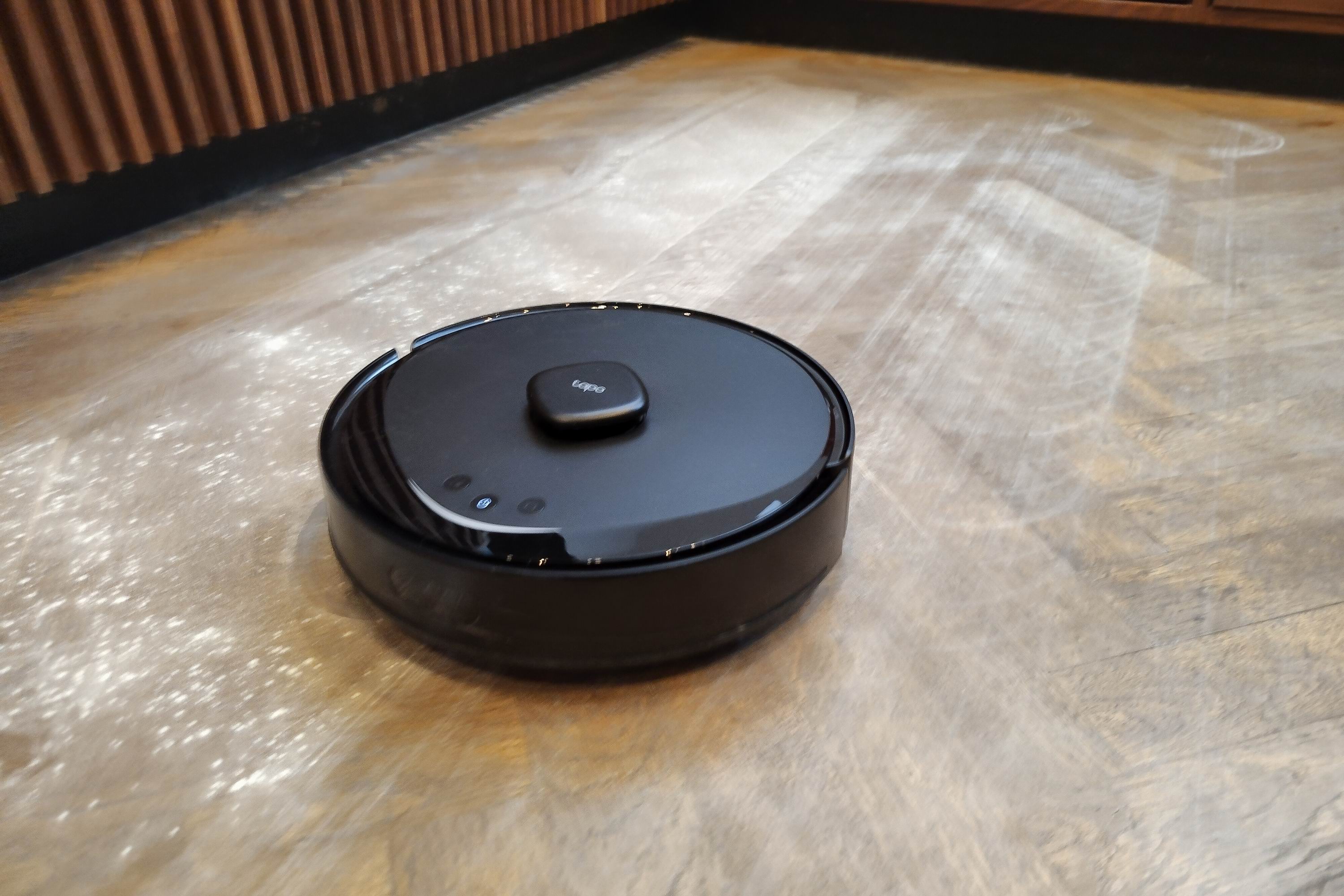 A robot vacuum cleans baby powder on a wooden floor