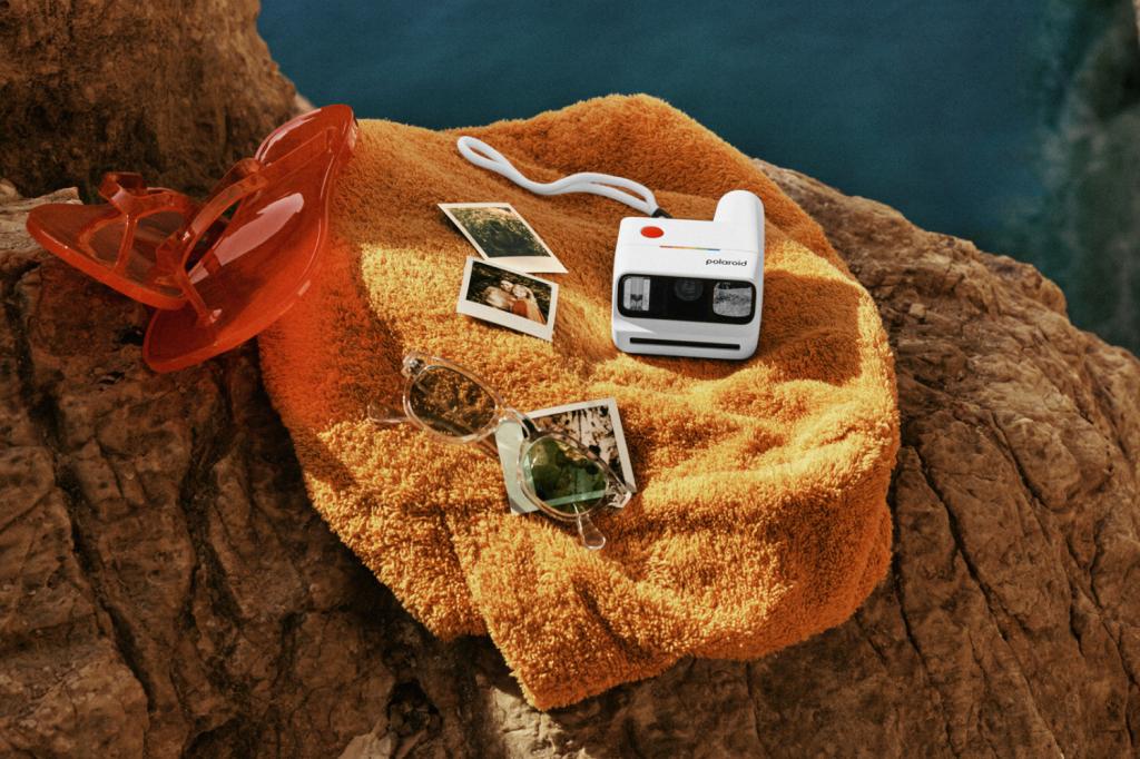 A white Polaroid Go Gen 3 camera on an orange towel